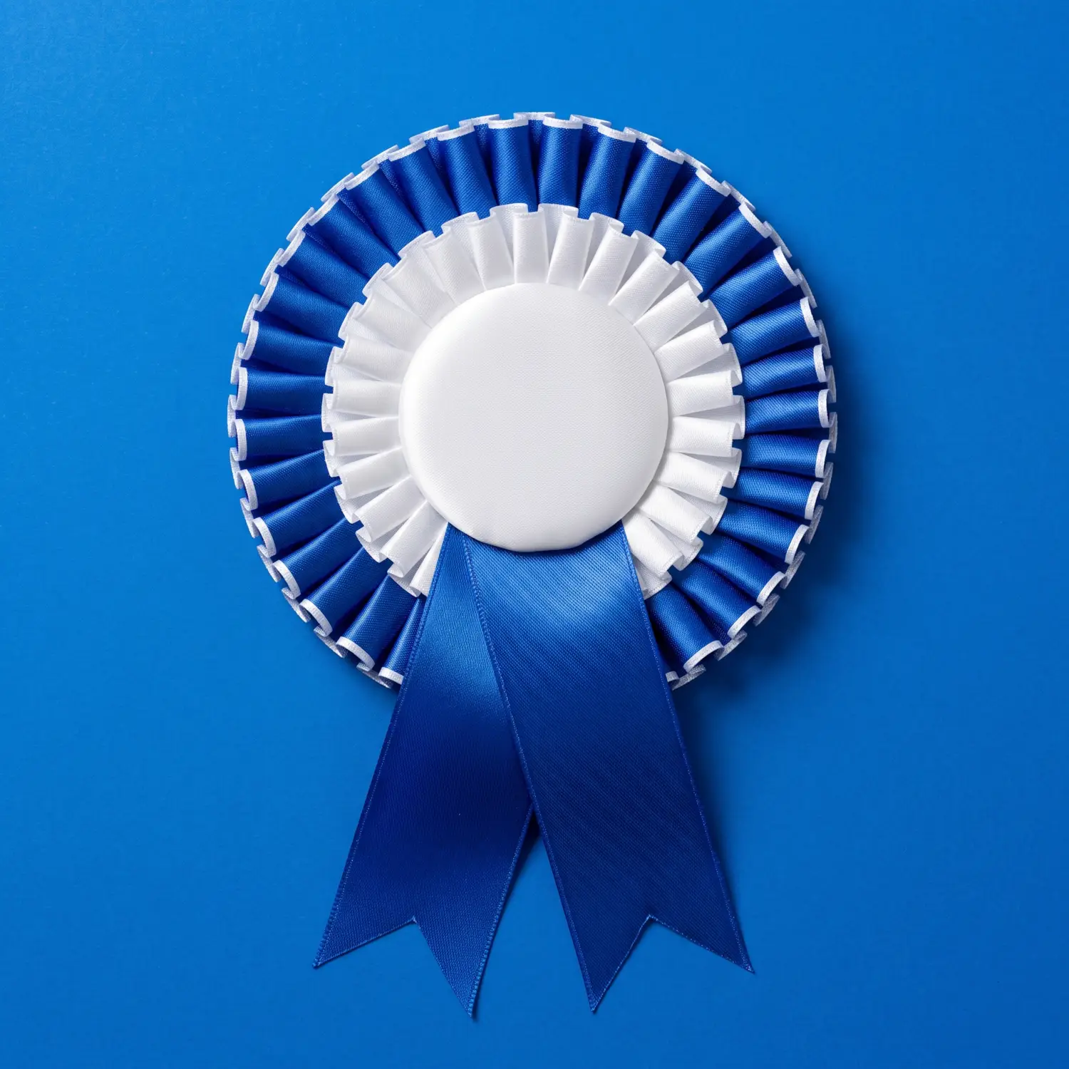 A large pleated satin rosette in royal blue and white, its plain white centre button carrying the headline.